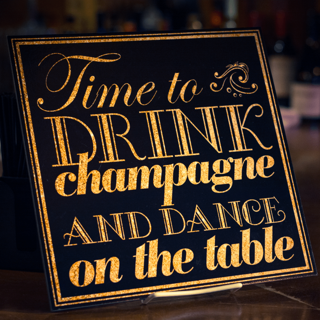 Drink champagne and dance on the table sign in black and gold
