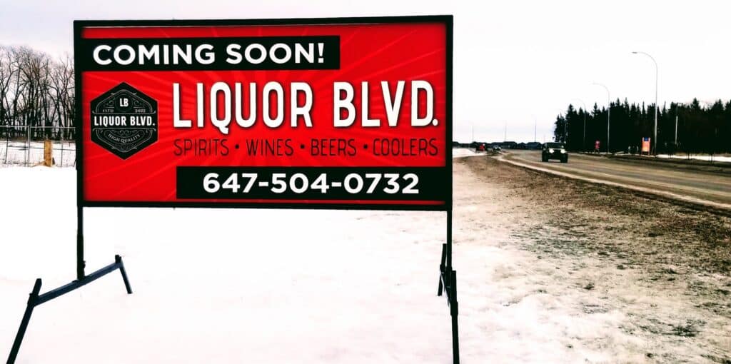 A temporary portable LED sign in red, black and white. Lettering says Coming soon: Liquor Blvd.

