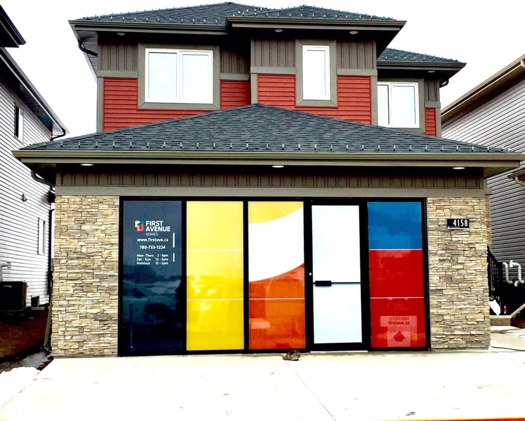 An image of a house, with the garage door replaced by windows with colourful decals on them, advertising the business within.